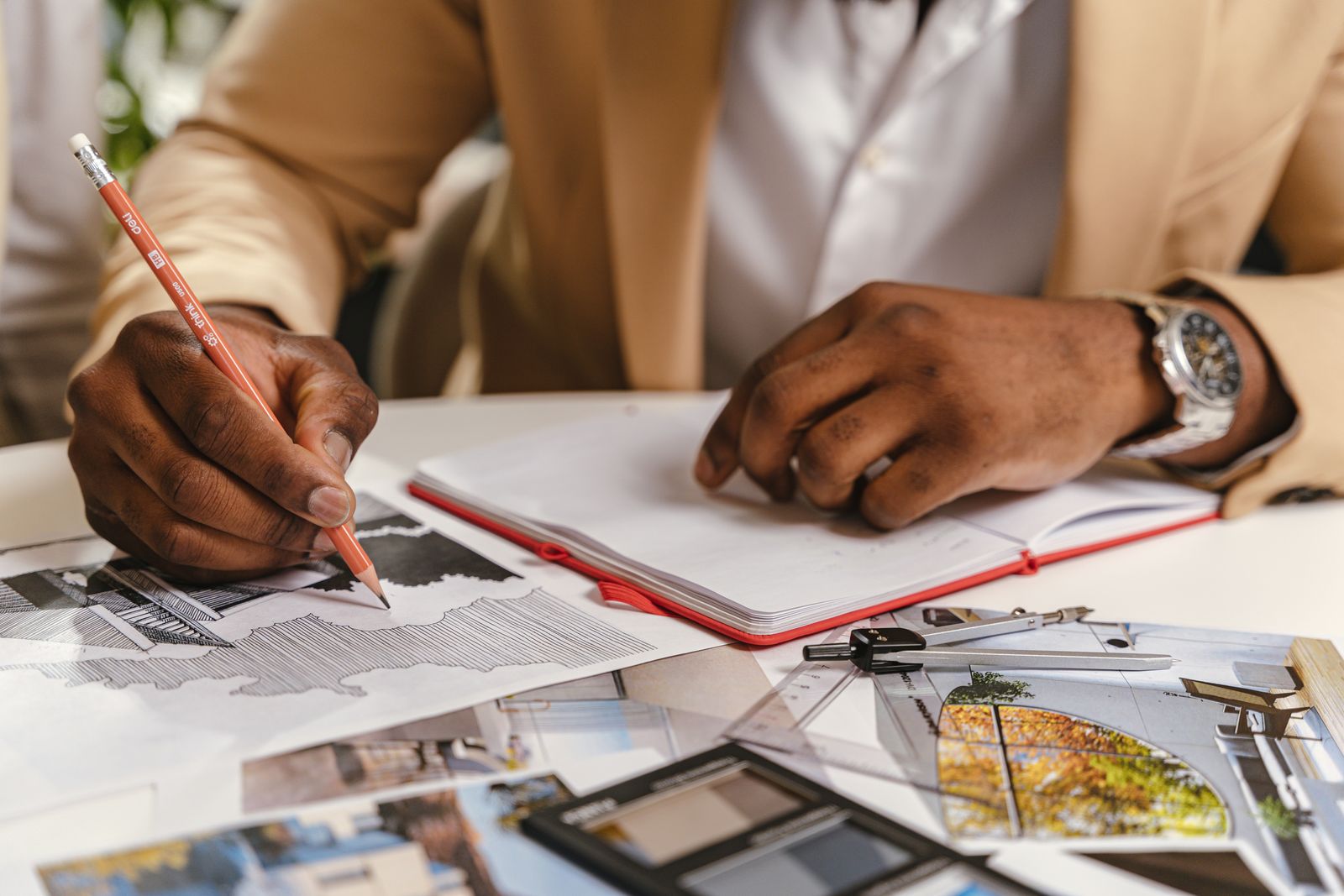 Architect sketching construction plans at a worktable