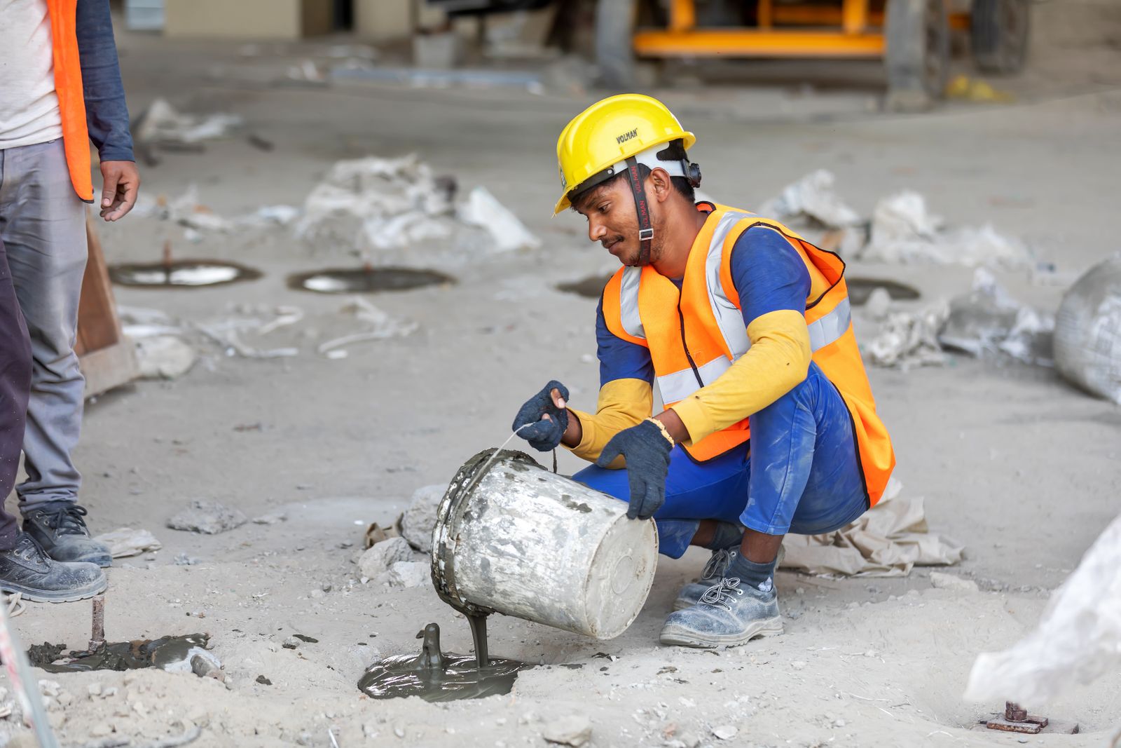 Construction worker pouring concrete on an active job site
