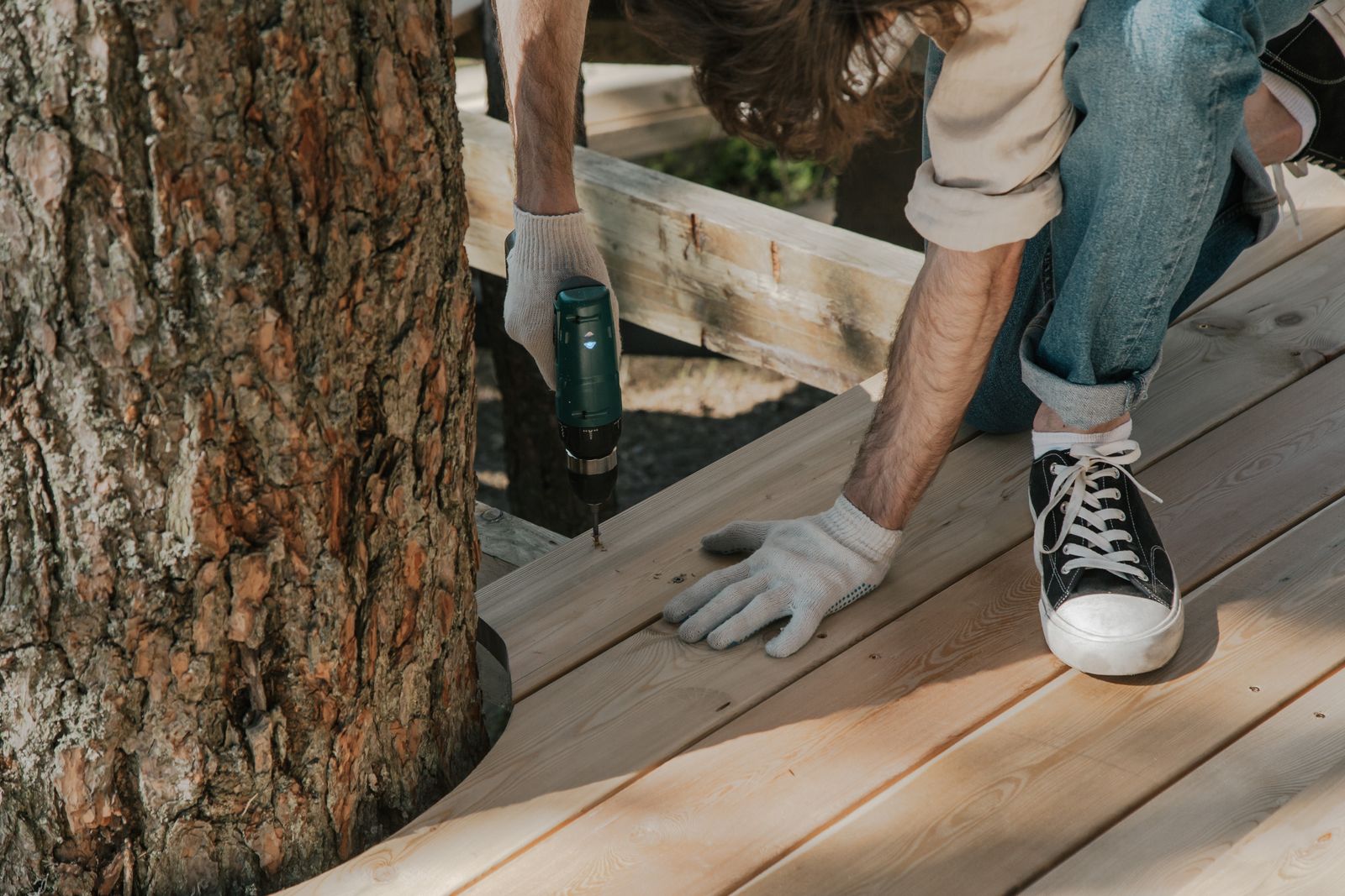 Carpenter fastening new wood deck boards