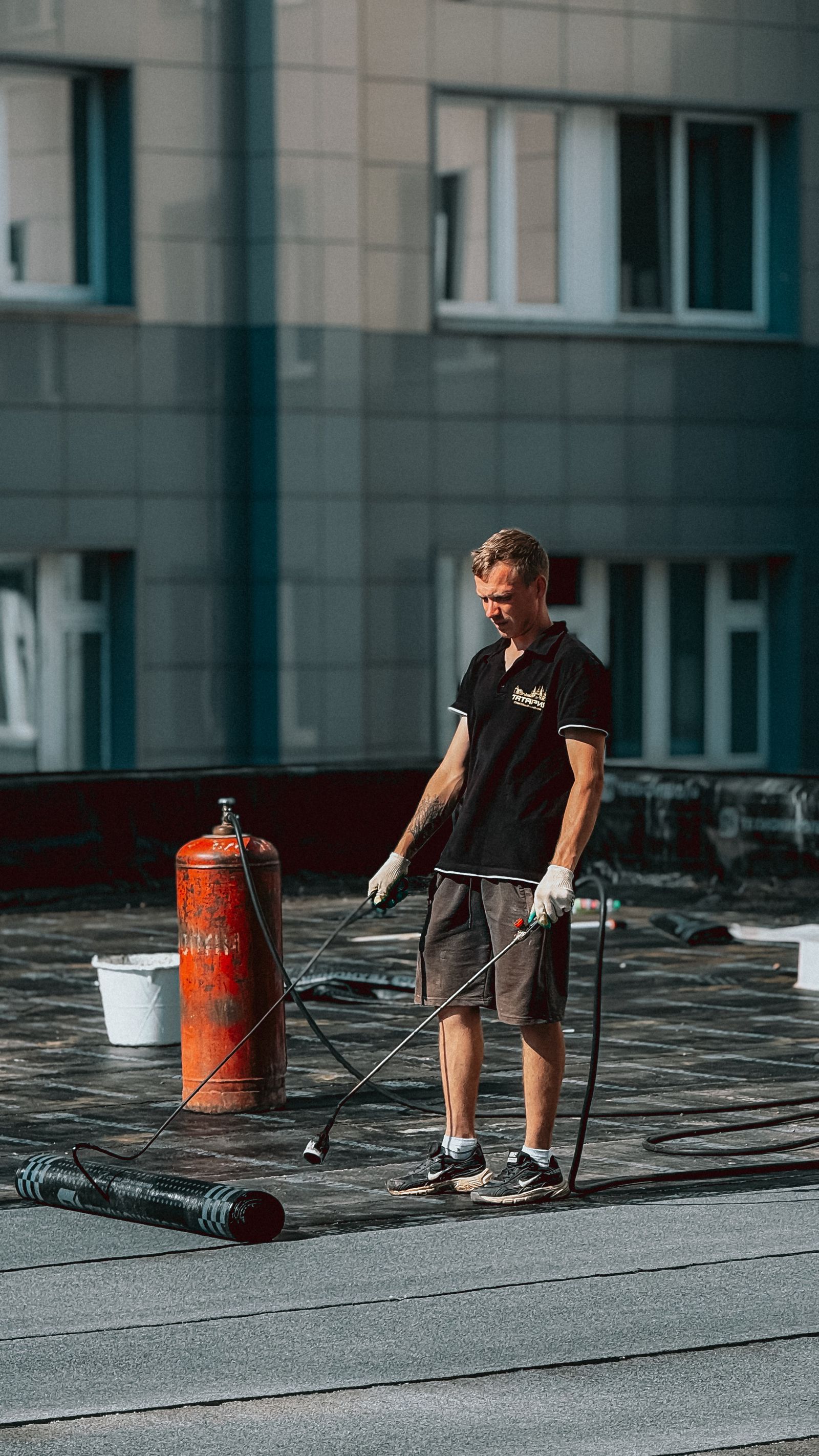 Roofer applying waterproof membrane on a flat roof