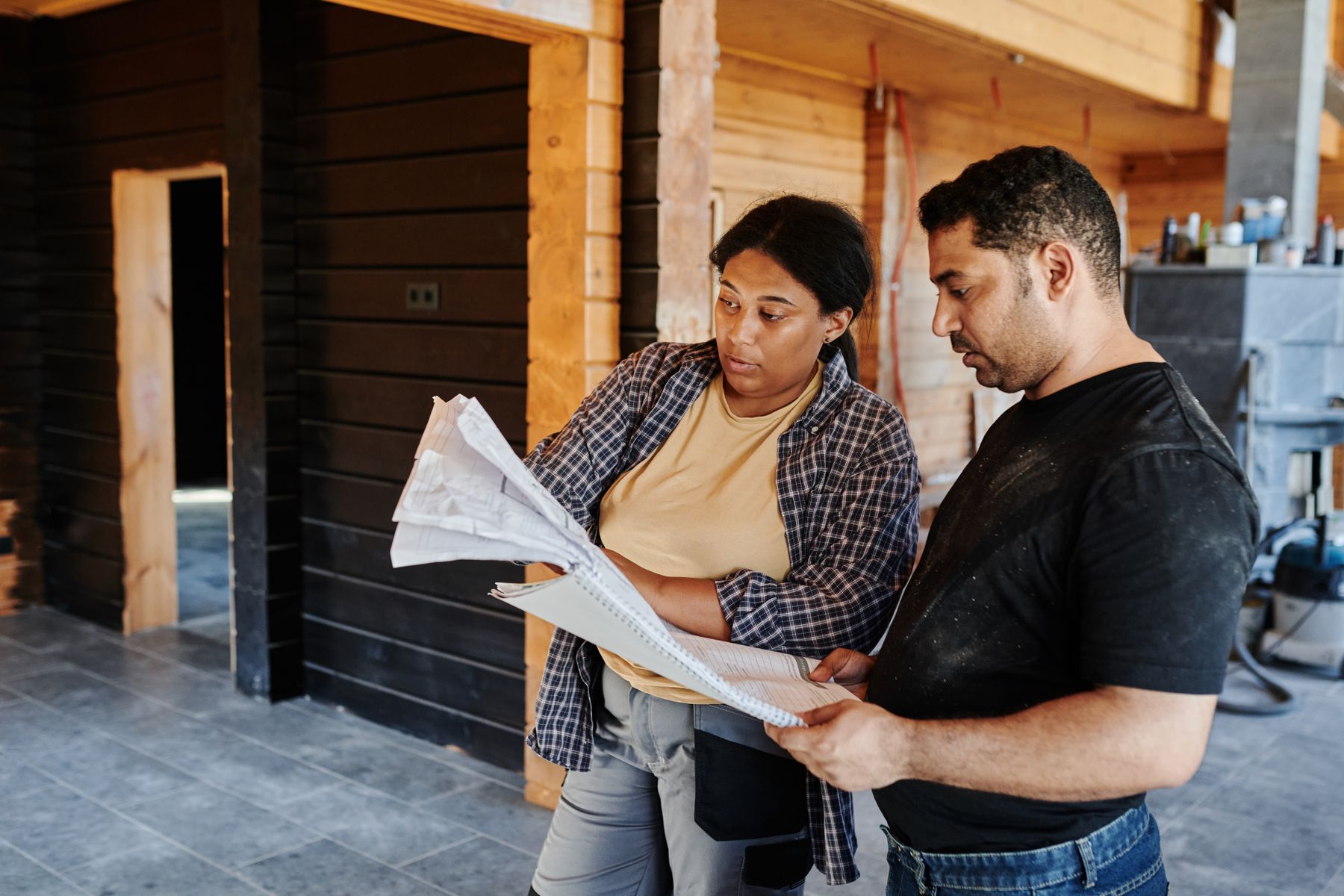 Two contractors reviewing project plans inside an active residential build