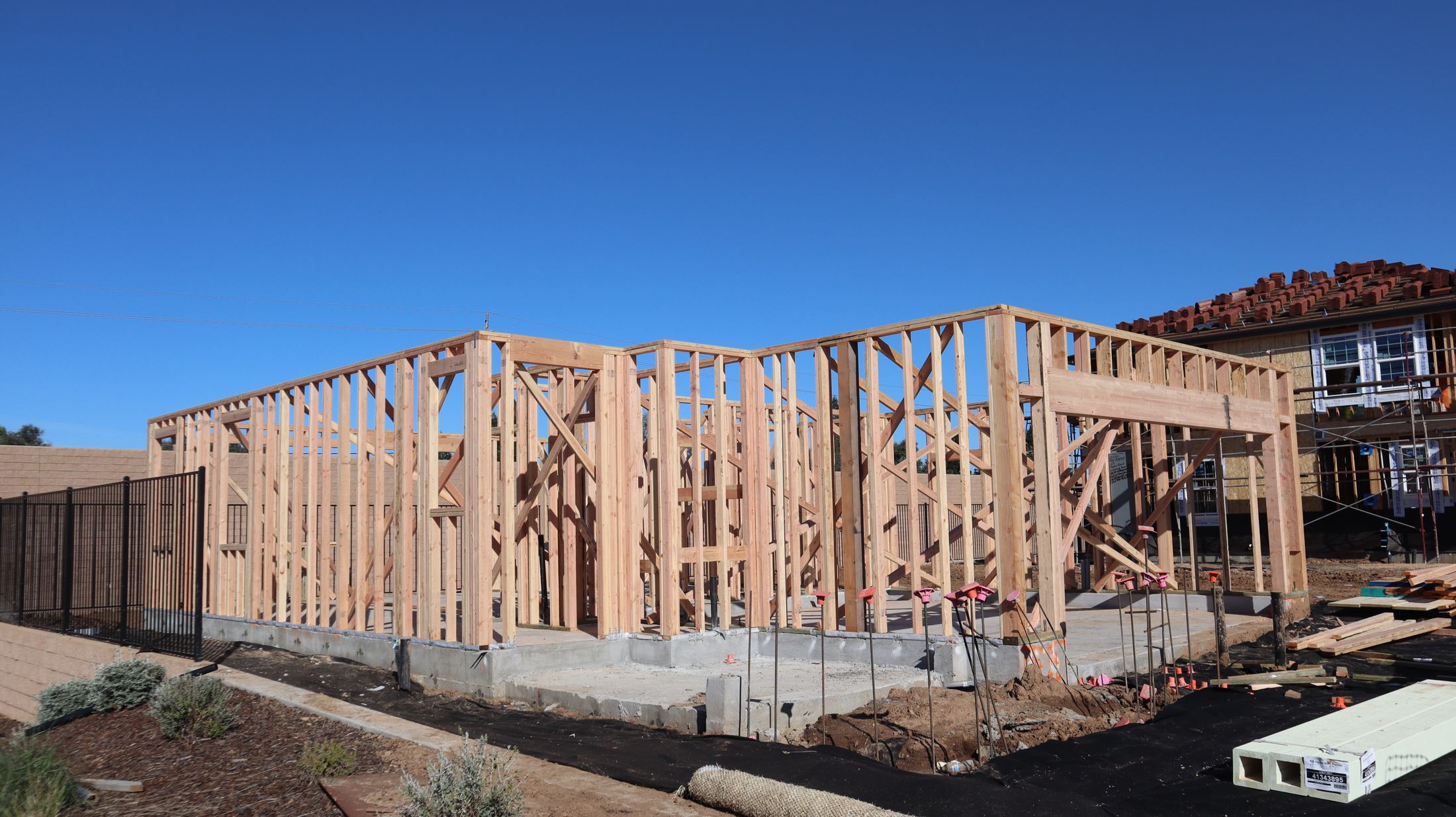 Wide view of a new residential structure with exterior wood framing in place