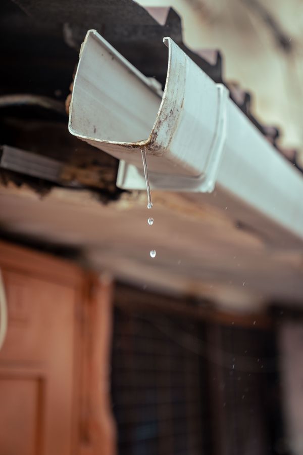 Close view of rainwater dripping from a residential gutter