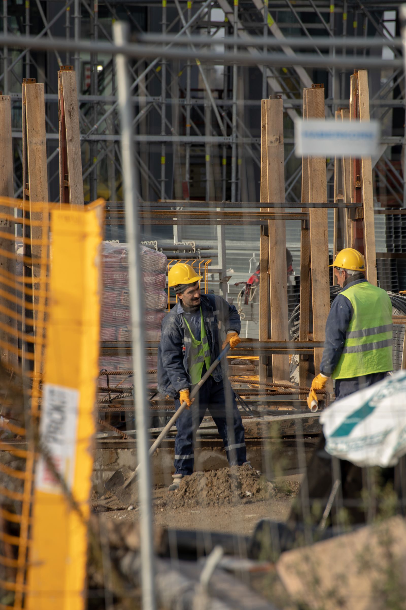 Construction workers handling materials on an active building site