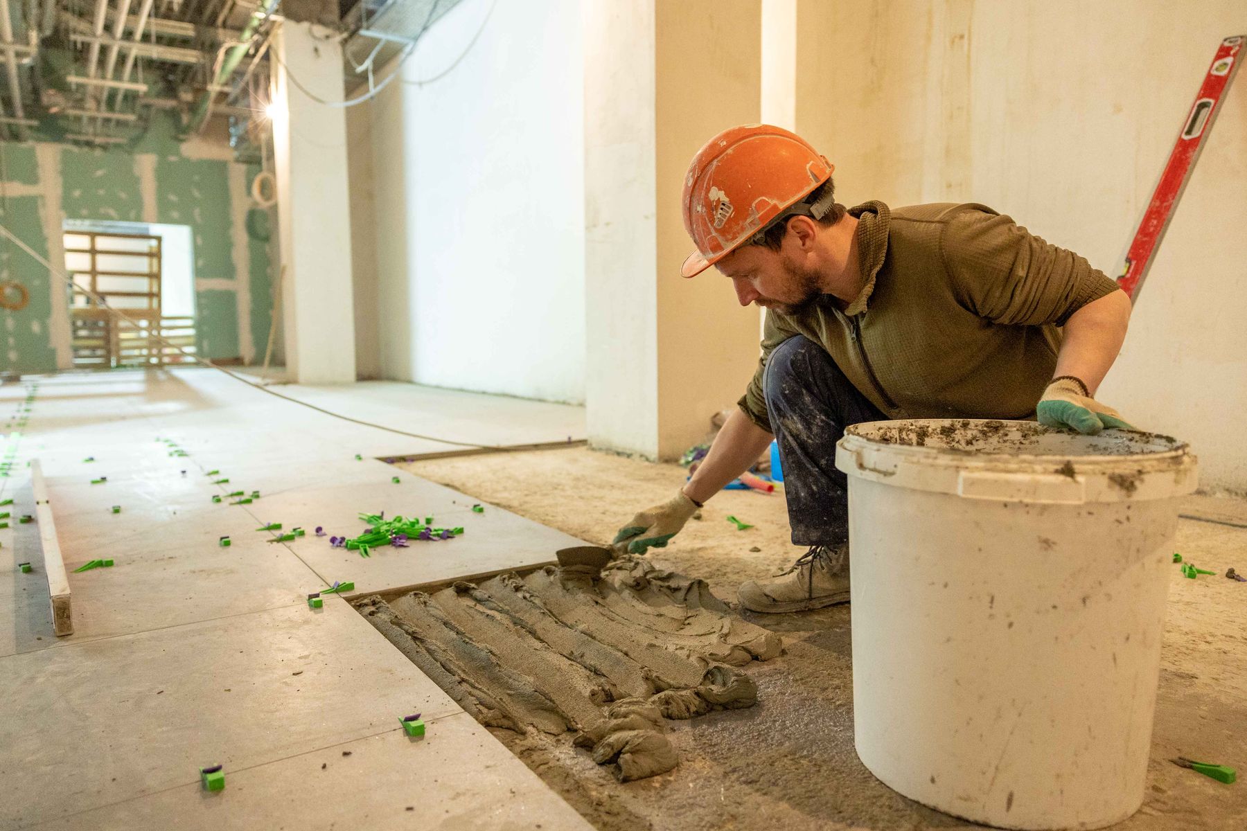 Tile installer spreading mortar during an interior renovation