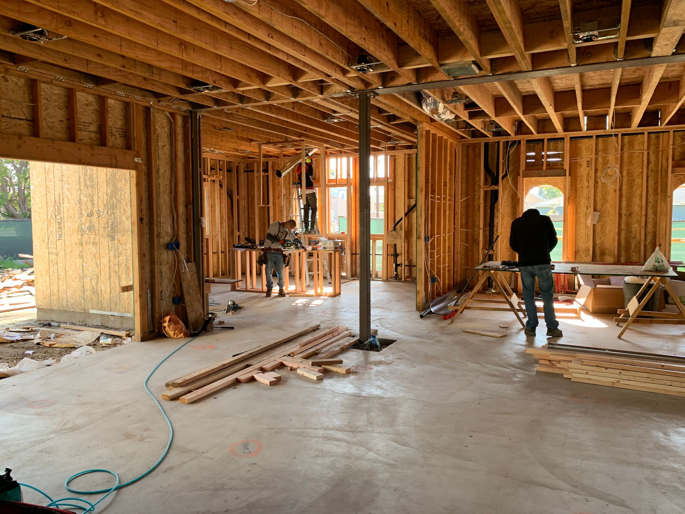 Construction crew working inside a wood-framed home
