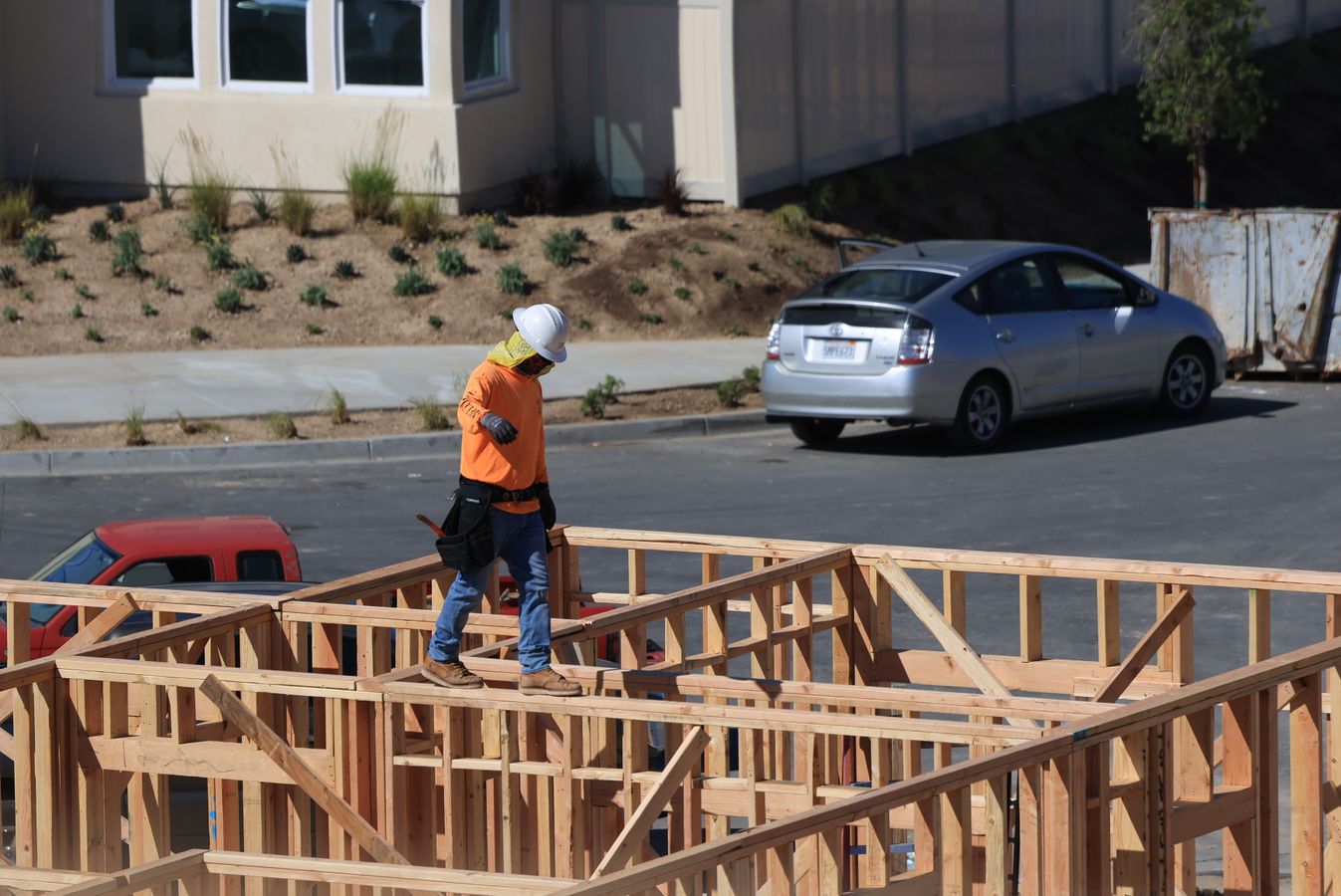 Construction worker moving across the wood framing of a new home